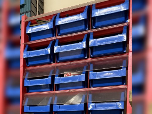 Gavetero de pared rojo con 12 cubetas azules